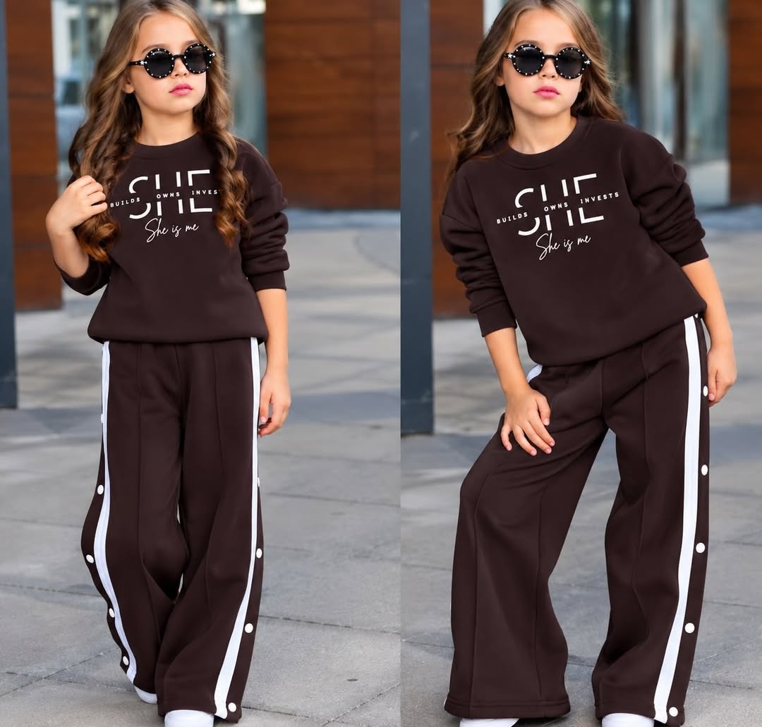 A child models a bright fuchsia sweatshirt and matching wide-leg track pants with white side stripes, shown in close and full-length views under daylight.